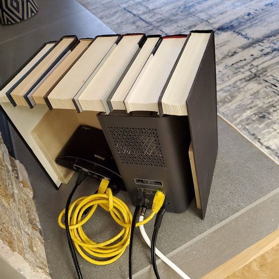 an open computer case sitting on top of a table next to a bunch of books