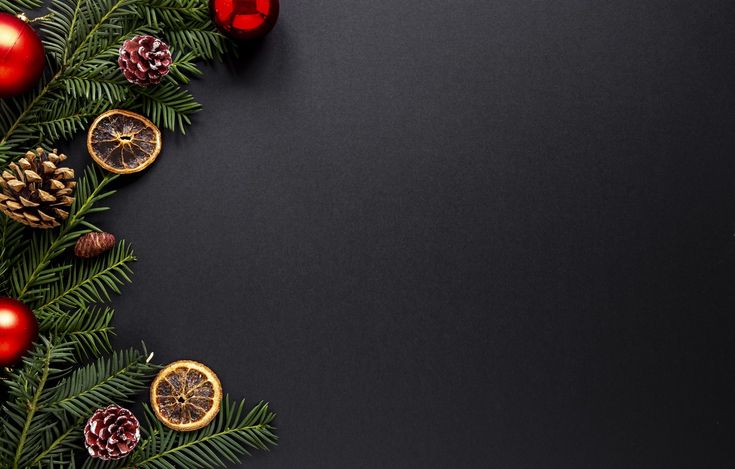 christmas decoration with pine cones, oranges and fir tree branches on black background top view