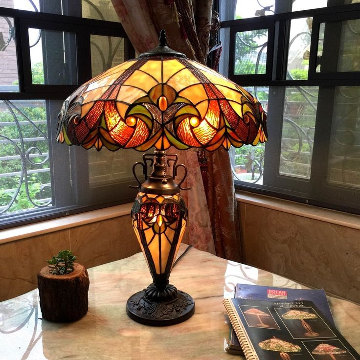 a lamp sitting on top of a table next to a book