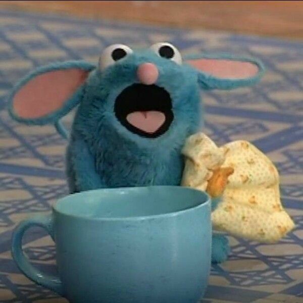 a blue cup with some chips in it and a stuffed animal holding a piece of bread