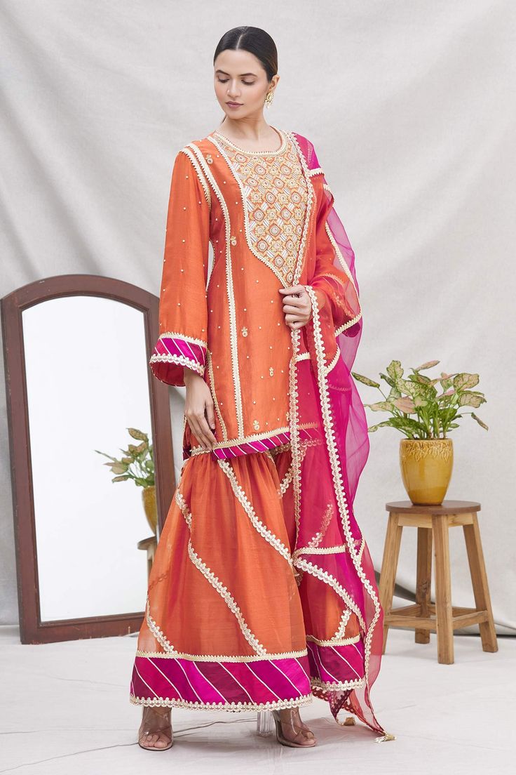 Rust kurta with floral motifs, dori patri hand work and bell sleeves. Comes with striped sharara pants and contrast tassel dupatta.
Components:3
Embroidered
Neckline:Round
Sleeve Length:Full
Fabric:Silk
Color:Orange
Bell sleeves
Striped pattern
Back keyhole
Elastic waistband
Tassel dupatta - Aza Fashions Tassel Dupatta, Sharara Pants, Kurta Sharara Set, Kurta Sharara, Silk Kurta, Sharara Set, Embroidered Neckline, Fabric Silk, Hand Work