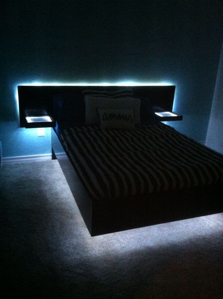 a bed with black and white sheets in a dark room