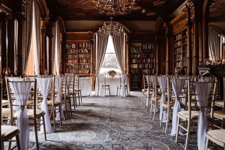 the library is set up for an event with white linens and chairs in it