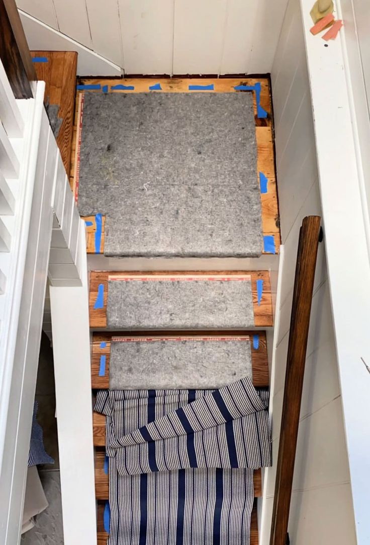 the stairs are being built into the wall in this small room with carpeted flooring