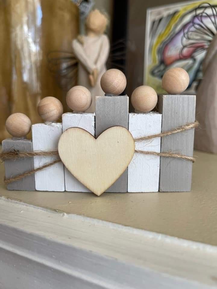 a small wooden block with a heart on it and some wood balls in the middle