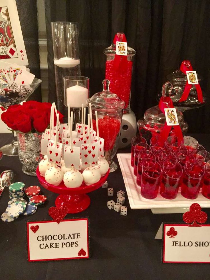 a table topped with lots of red and white desserts next to candy bars on top of each other