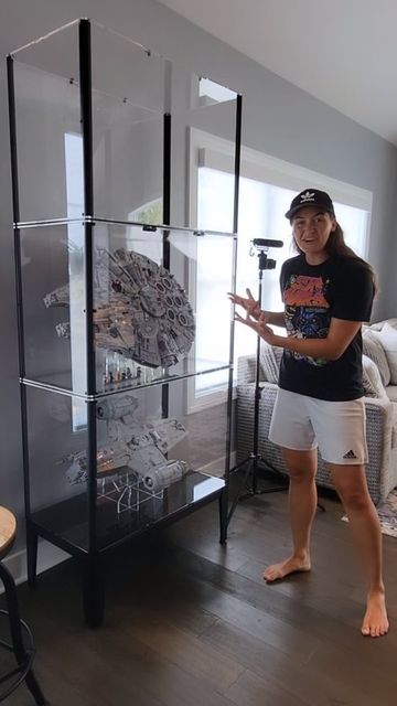 a woman standing in front of a glass display case