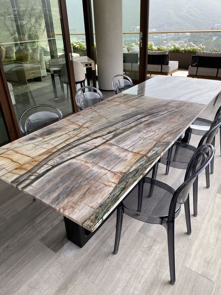 a large wooden table sitting on top of a hard wood flooring covered dining room