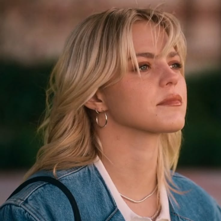 a woman with blonde hair wearing a denim jacket