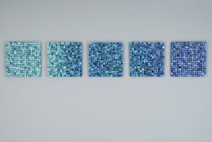 four pieces of blue glass mosaic tile on a wall