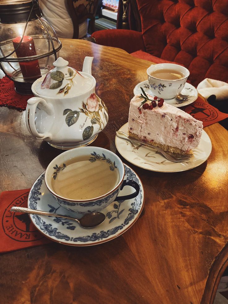 there is a piece of cake on the table next to two cups and saucers