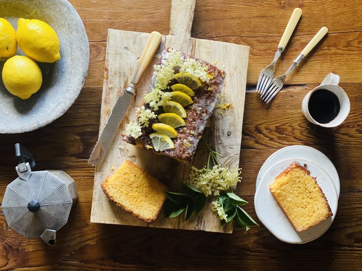 there is a cake on the table with lemons and other food items around it