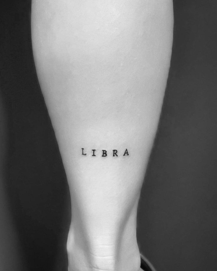 a black and white photo of a person's leg with the word libra on it