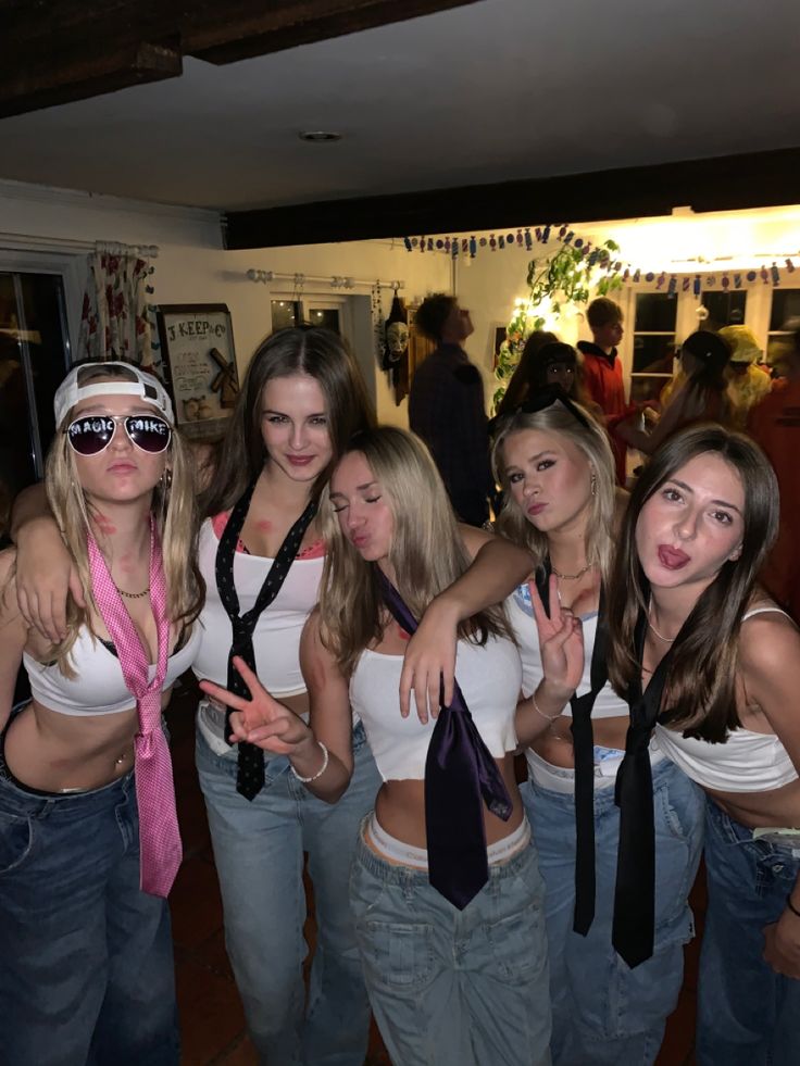 a group of young women standing next to each other in front of a bar wearing neck ties