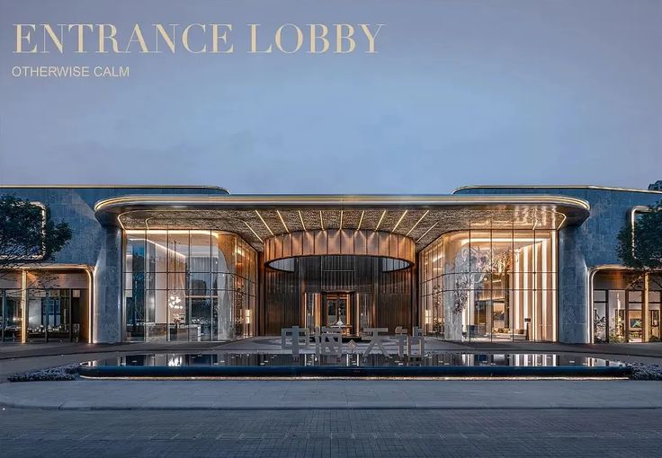 an entrance lobby with tables and chairs in front of it at dusk or dawn time