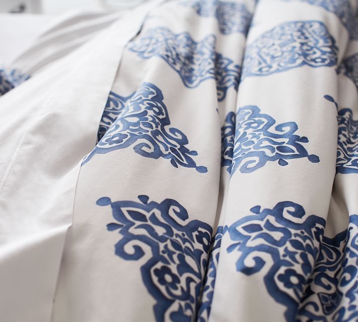 the blue and white bedding has an intricate design on it's coverlet