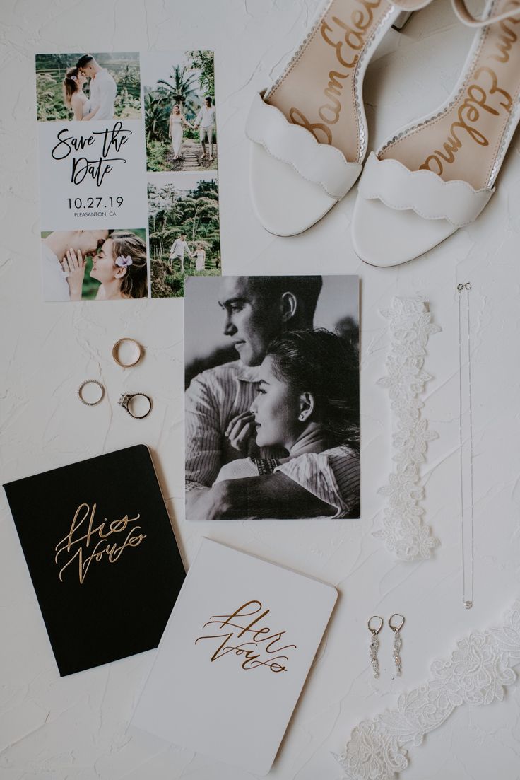 the wedding stationery is laid out on top of the bride's dress and shoes