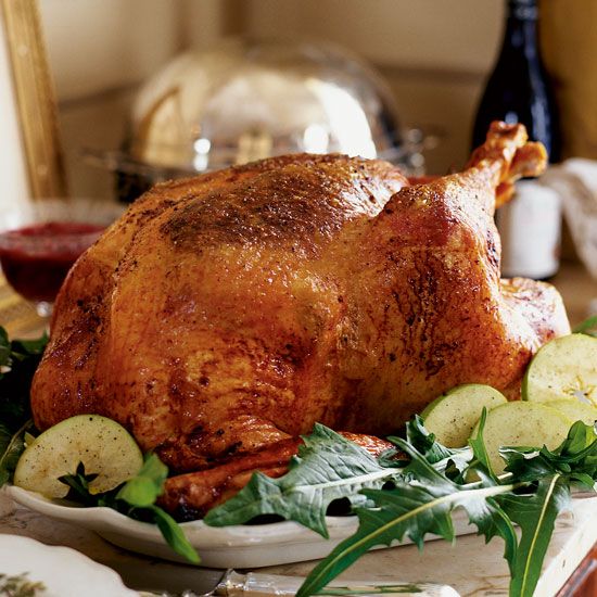 a roasted turkey on a platter with garnishes