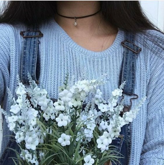 a woman wearing overalls and holding a bouquet of flowers in her hands with the caption's below it