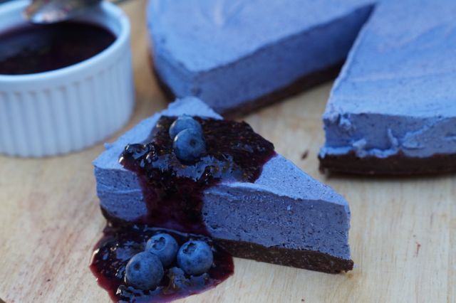 a piece of blueberry cheesecake on a cutting board