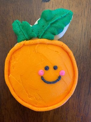 an orange shaped cake with a green leaf on top