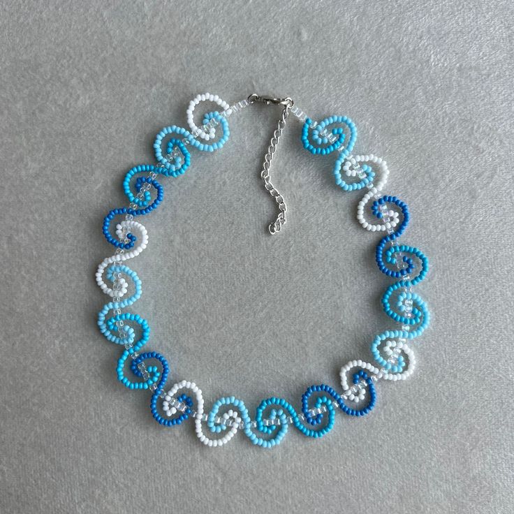 a blue and white beaded bracelet on a gray surface