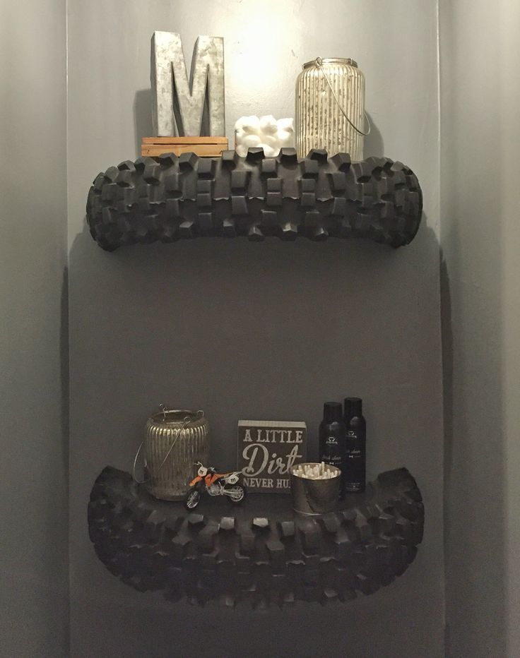 the bathroom is decorated in black and white with an interesting shelf that holds personal items