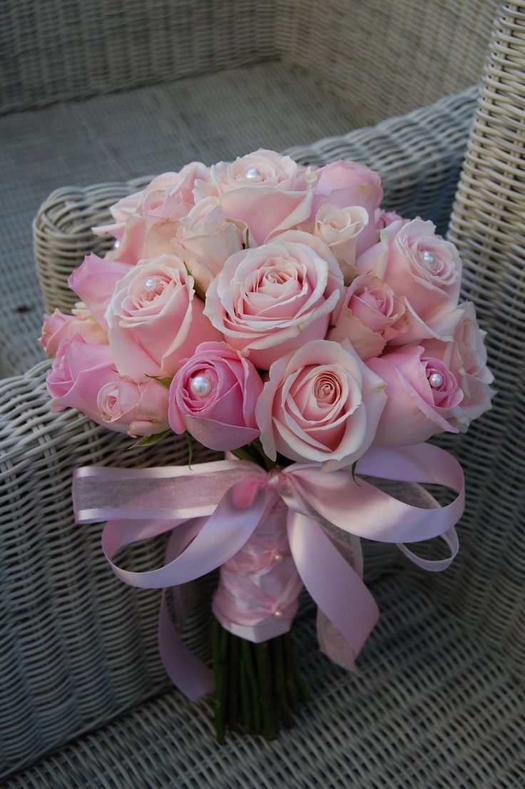 a bouquet of pink roses sitting on top of a chair