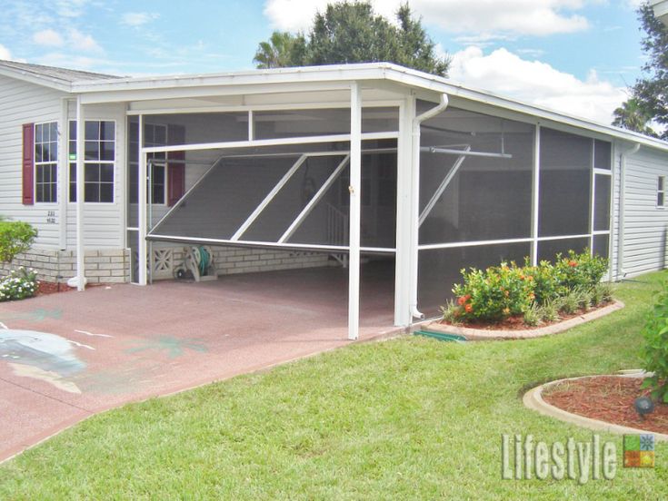 a white house with a screened porch in the front yard