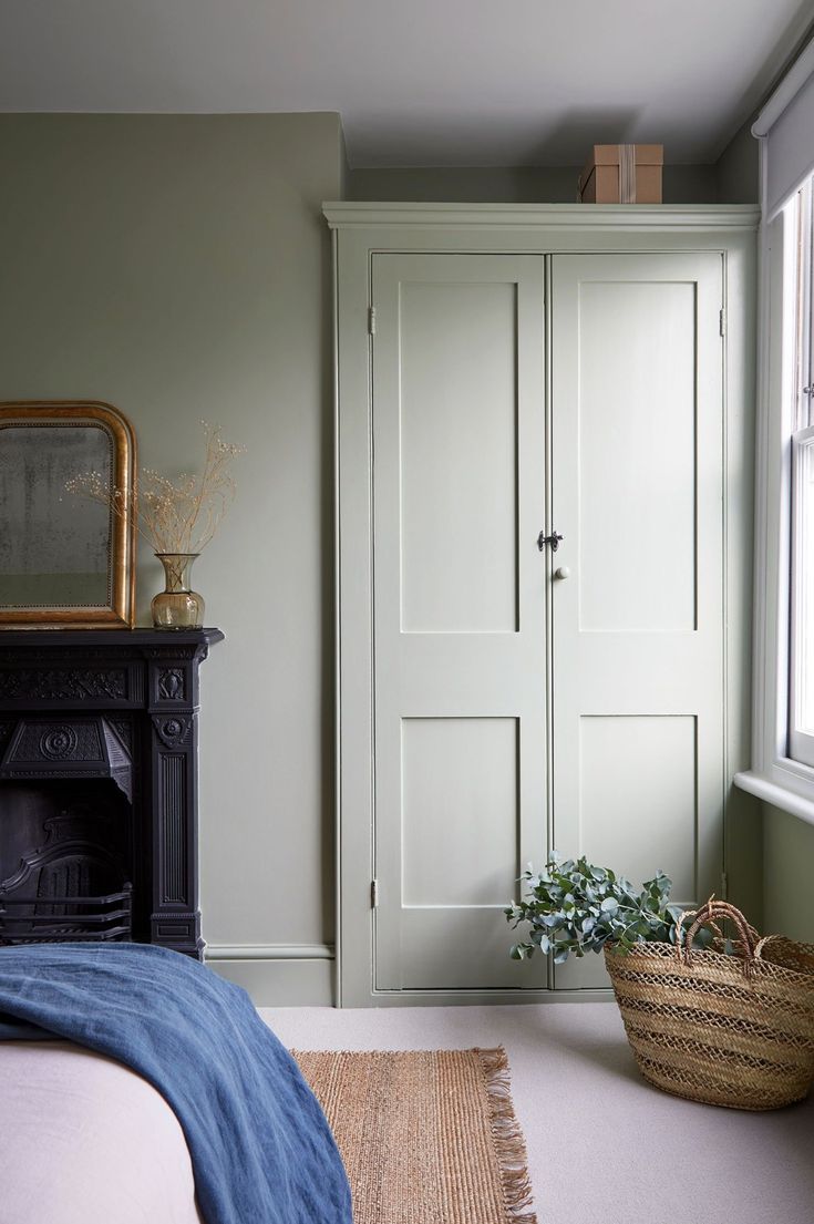 a bedroom with an armoire, bed and basket on the floor next to it