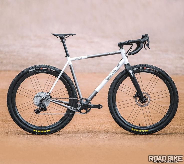 a bike parked on the side of a dirt road