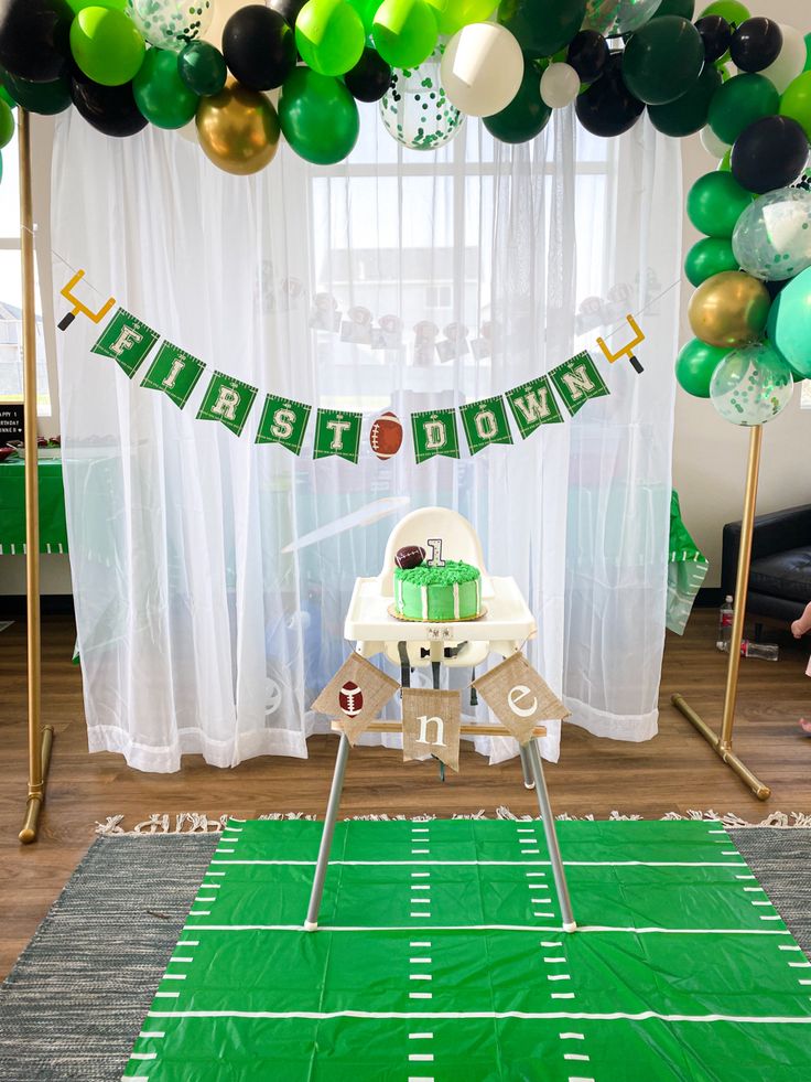 a football themed birthday party with green and white balloons, streamers, and cake