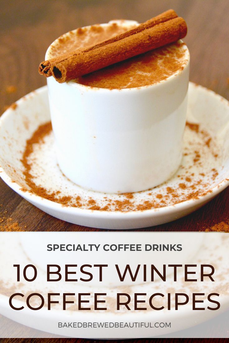 a white cup filled with coffee and cinnamon on top of a wooden table