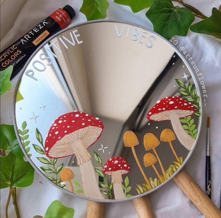 a mirror with mushrooms painted on it next to some markers and paintbrushes,