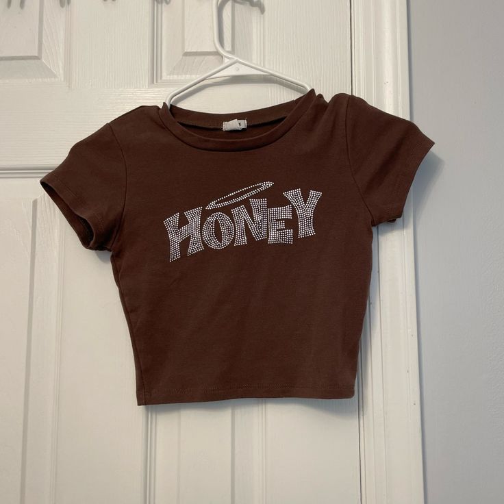 Garage Baby Tee Shirt. Size:Xs. Never Worn Cute Brown Crew Neck T-shirt, Brown Crew Neck Top With Letter Print, Fitted Brown Top With Graphic Print, Brown Fitted Graphic Print Tops, Brown Fitted Top With Graphic Print, Brown Short Sleeve Y2k Top, Brown Cotton Tops With Graphic Print, Cute Brown Summer T-shirt, Brown Cotton Tops With Logo Print