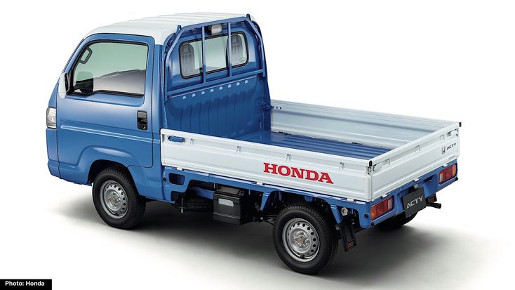 the truck is blue and white with red lettering on it's side, parked in front of a white background