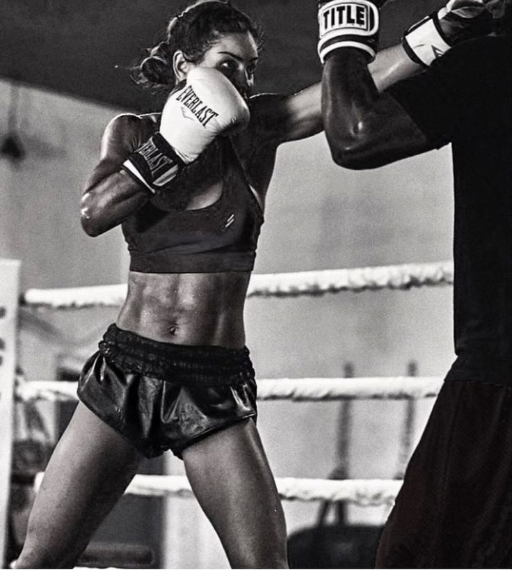 a black and white photo of two women boxing