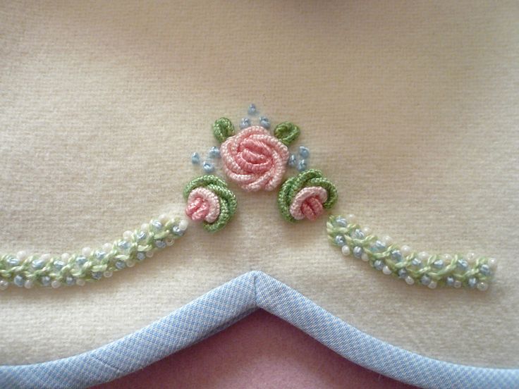 there is a piece of cloth with flowers on it and beads around the edges that have been stitched together