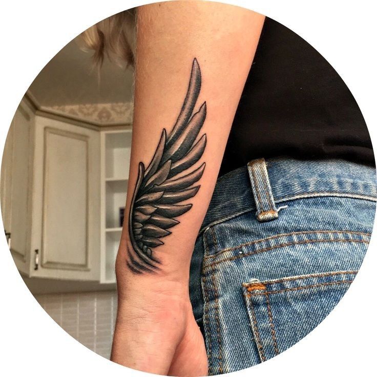 a woman's arm with a tattoo on it and an image of a feather