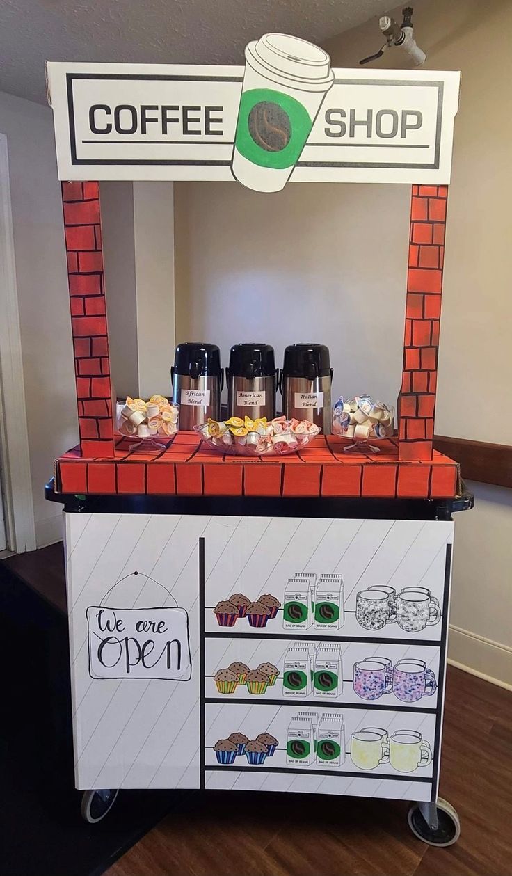 a coffee shop stand with cupcakes and other items on it's display