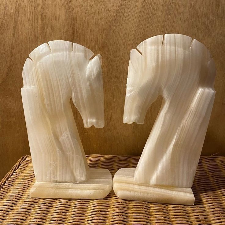 two sculptures made out of banana peels sitting on a wicker tableclothed surface