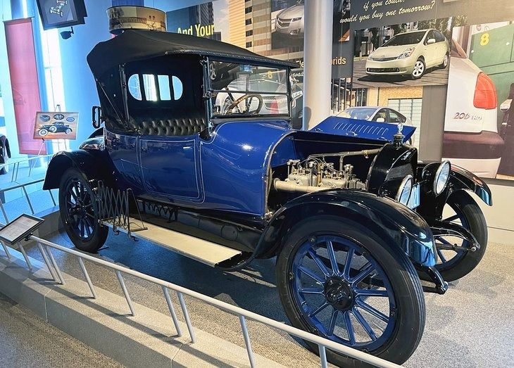 an antique blue car on display in a museum