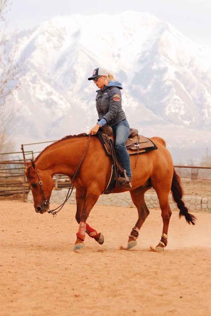 a woman riding on the back of a brown horse