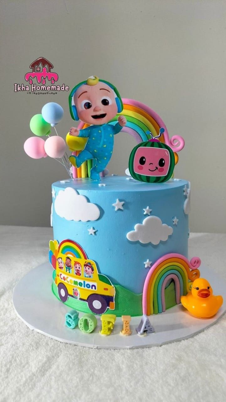 a birthday cake decorated with an image of a child's character and rainbows