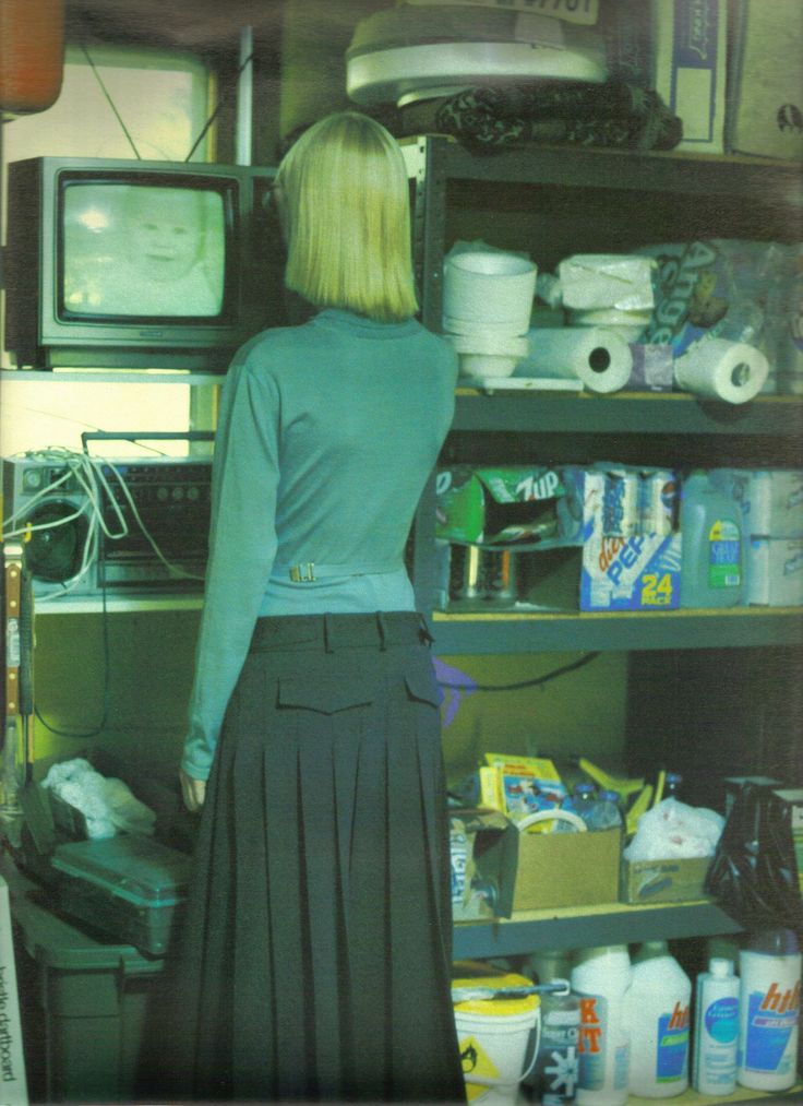 a woman standing in front of a shelf full of items