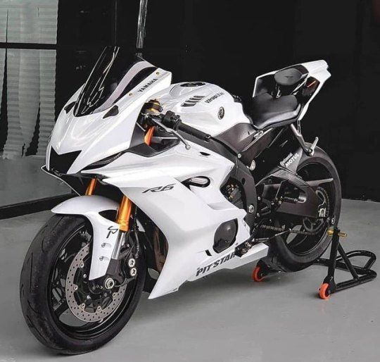 a white and black motorcycle parked in a garage