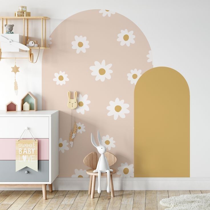 a child's room with flowers painted on the wall and wooden toys in the foreground