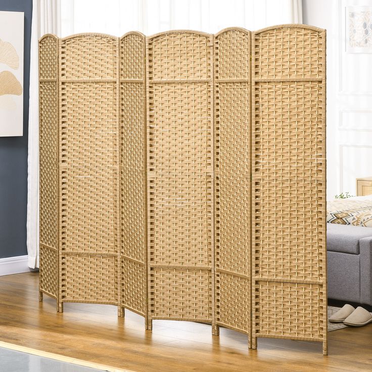 a room divider made out of wicker with a couch in the back ground