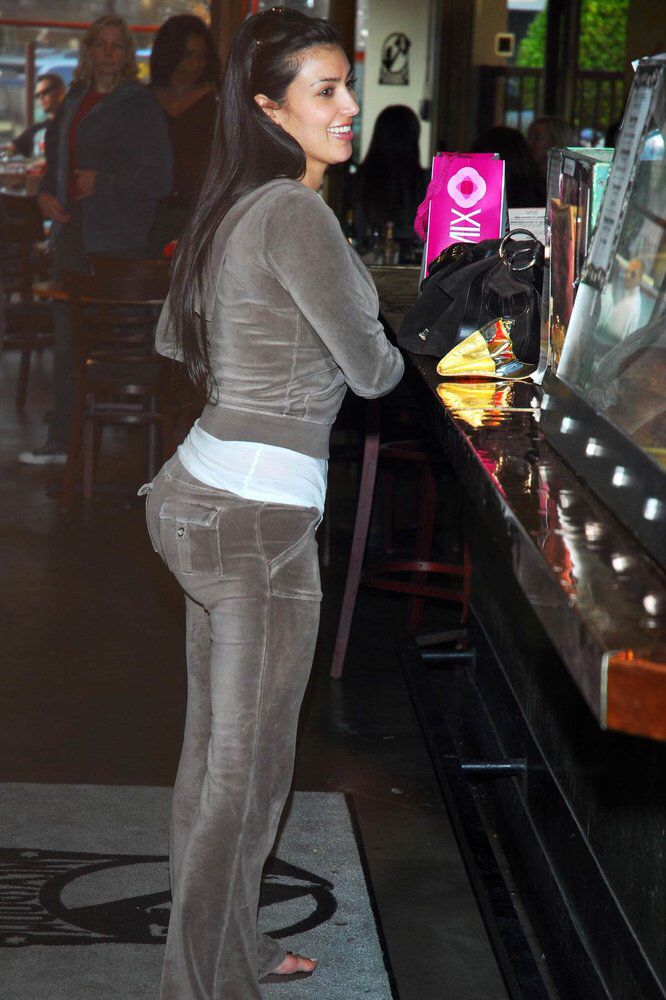 a woman standing at a bar with her cell phone