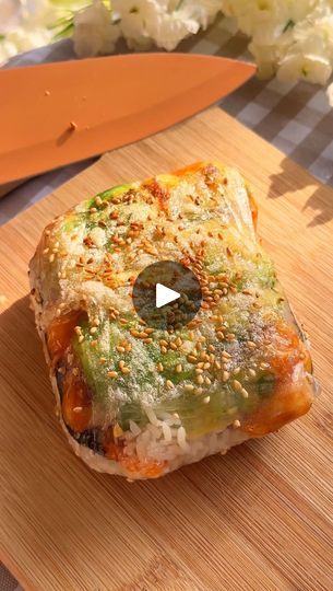 a piece of food sitting on top of a wooden cutting board next to a knife